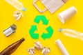 Recycling. Green recycle eco symbol. Recycled arrows sign near matherials for recycle and reuse on yellow background top Royalty Free Stock Photo