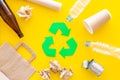 Recycling. Green recycle eco symbol. Recycled arrows sign near matherials for recycle and reuse on yellow background top Royalty Free Stock Photo