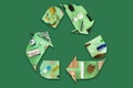 Recycling icon mocked up of different types of waste materials on green background.