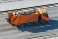 Recycling orange truck rides on the road in the city