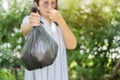 Recycling, sorting and sustainability concept - young Asian woman holding stinky trash plastic bag Royalty Free Stock Photo
