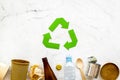 Recycling symbol and different garbage on marble background top view Royalty Free Stock Photo