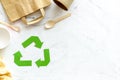 Recycling symbol and different garbage, paper bag, cup, flatware for ecology on marble background top view mock up Royalty Free Stock Photo