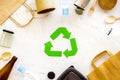 Recycling symbol and different garbage, paper bag, cup, flatware, plastic bottle for ecology marble background top view Royalty Free Stock Photo