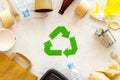 Recycling symbol and different garbage, paper bag, cup, flatware, plastic bottle for ecology marble background top view Royalty Free Stock Photo