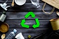 Recycling symbol and different garbage, paper bag, cup, flatware, plastic bottle for ecology wooden background top view Royalty Free Stock Photo