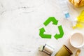 Recycling symbol and different garbage, paper cup, plastic bottle, can for ecology on marble background top view mock up Royalty Free Stock Photo