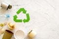 Recycling symbol and different garbage, paper cup, plastic bottle, can for ecology on marble background top view mock up Royalty Free Stock Photo