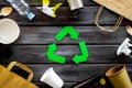 Recycling symbol and different garbage on wooden background top view Royalty Free Stock Photo