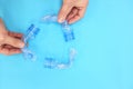 Recycling symbol made of plastic bottles in blue background. Flat lay composition. Reduce, reuse, recycle concept. Royalty Free Stock Photo