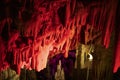 Red abstract background of stalactites, stalagmites and stalagnates in a cave underground, horizontal