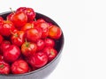 Red acerola cherries fruit in a ceramic bowl isolated on a white background. Royalty Free Stock Photo