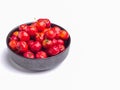 Red acerola cherries fruit in a ceramic bowl isolated on a white background. Royalty Free Stock Photo