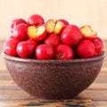 Red acerola (malpighia glabra), tropical fruit in brown bowl