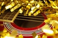 Red acustic guitar, strings and tinsel