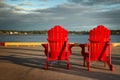 Red adirondack chairs in front of water Royalty Free Stock Photo