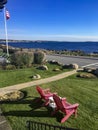 Red Adirondack Chairs on a Lawn Overlooking the Sea in New England Royalty Free Stock Photo