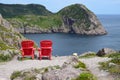 Red Adirondack chairs overlooking the ocean and coastline Royalty Free Stock Photo
