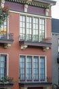 Red or adobe stucco exterior on modern building or home with visible windows and metal grate decorative balconies Royalty Free Stock Photo