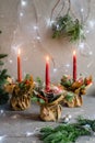 Red advent flower arrangement with three burning candles Royalty Free Stock Photo