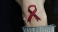 Red AIDS ribbon tattoo on wrist. Generative AI