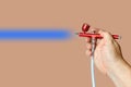 Red airbrush spray tool in hand for paintingg hobby or work Royalty Free Stock Photo