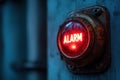 Red alarm button with rusty metal base in dimly lit industrial setting highlighting industrial safety alert
