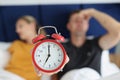 Red alarm clock against the background of a sleeping couple Royalty Free Stock Photo