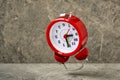 Red alarm clock falling on the stone background