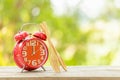 Red alarm clock, Fork, and spoon on wooden table with green outdoor nature blur background. Eight o'clock, Time for eating concep Royalty Free Stock Photo