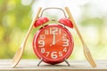 Red alarm clock, Fork, and spoon on wooden table with green outdoor nature blur background. Eight o'clock, Time for eating concep Royalty Free Stock Photo