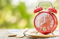 Red alarm clock, Fork, and spoon on wooden table with green outdoor nature blur background. Eight o'clock, Time for eating concep Royalty Free Stock Photo