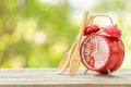 Red alarm clock, Fork, and spoon on wooden table with green outdoor nature blur background. Eight o'clock, Time for eating concep Royalty Free Stock Photo