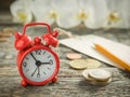 Red alarm clock Notepad for writing pencil Euro Money coins on wooden rustic table Royalty Free Stock Photo