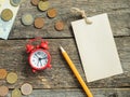 Red alarm clock Notepad for writing pencil Euro Money coins on wooden rustic table Royalty Free Stock Photo