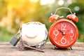 Red alarm clock with piggy bank a key on old wood Royalty Free Stock Photo