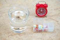 Red alarm clock,daily pill box and glass of water Royalty Free Stock Photo