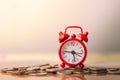 Red alarm clock on stack of coins in concept of savings and money growing or energy save. Royalty Free Stock Photo