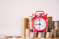 Red alarm clock on stack of coins in concept of savings and money growing or energy save. Royalty Free Stock Photo