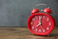 Red alarm clock on wooden desk and Loft wall background and copy space