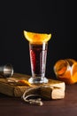 Red alcohol coctail in shot glass with orange slice and ground red hot pepper on wooden board Royalty Free Stock Photo