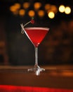 Red alcoholic cocktail decorated with berry at wooden table. Transparent glass of alcoholic drink isolated on black Royalty Free Stock Photo