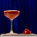 Red alcoholic cocktail in martini glass on blue background, shallow dof Royalty Free Stock Photo