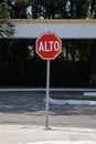 Red Alto - stop - sign on the road surrounded by greenery under the sunlight in Mexico