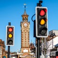 Red And Amber Traffic Lights With Clock Tower In Background