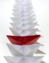 Red amongst white paper ships Royalty Free Stock Photo