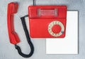 Red antique rotary phone with blank sheet of paper