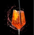 Red aperitif with straw and splash of water-