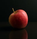 Red Apple on black reflective surface