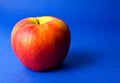 Red apple on blue background Royalty Free Stock Photo